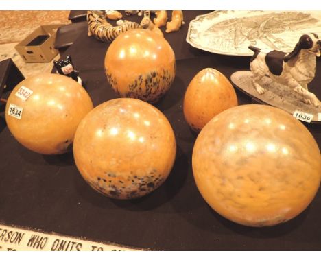 Four globe shaped and one teardrop shaped glass light shades with a multi coloured speckle on orange base 
