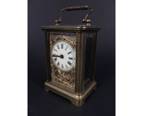 A brass cased carriage clock with relief cherub and floral decorated dial