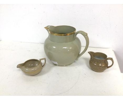 A group of three ceramic jugs, one possibly inscribed Wedgwood to base, all with gilt decoration (largest: 17cm) (a/f)