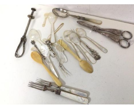 An assortment of bone and mother of pearl spoons, Epns grape scissors, a fork with silver collar and another with silver tong