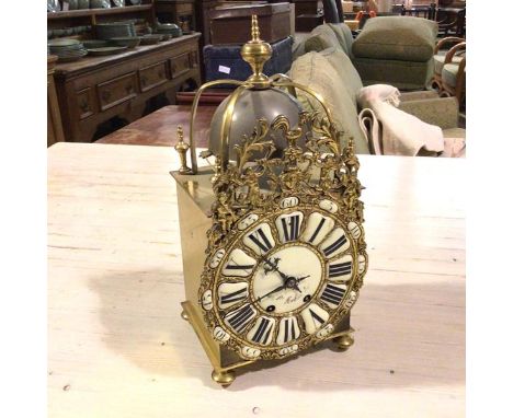 An H &amp; F Paris reproduction brass lantern style clock, with turned finial and brass straps, above a pewter bell, with bra