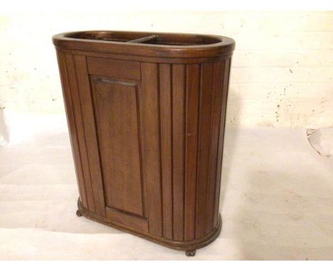 A 1920s oval mahogany two division stick stand with moulded top with copper division and coopered style sides, raised on plin