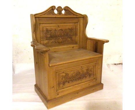 A reproduction pine miniature hall bench with broken swan neck pediment to top and relief carved shell and foliate panel back