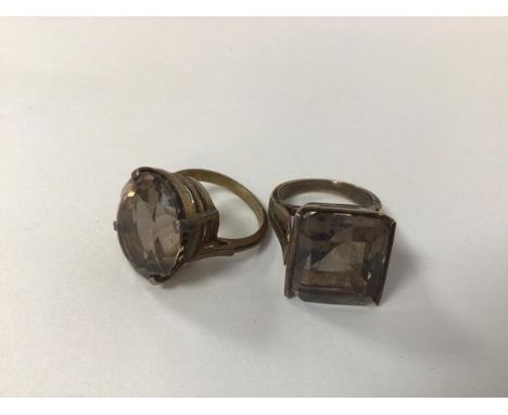 Two rings each set a light grey stone, one oval cut, the other square cut, both in gilt metal mounts (larger size: O)