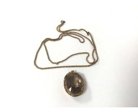 A yellow metal necklace (approximately 30cm) and a pendant set light grey stone in gilt metal mount