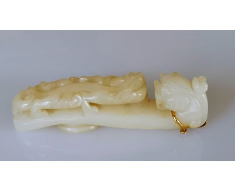 A 19th century Chinese white jade belt buckle hook with carved dragon head and chilong surmount to shaft, 9cm, with later gol