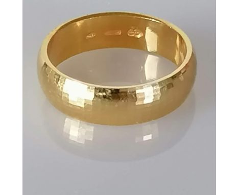 An 18ct yellow gold wedding band with textured finish, hallmarked, size K, 4.3g
