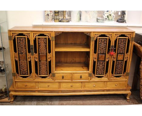 A Chinese Hardwood Sideboard; the sideboard having cupboard to either side, one-shelf recess between and seven drawers (af) o