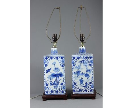 Two Chinese Blue and White Ceramic Lamp Bases; the bases depicting figures in a garden, supported on wooden stands, approx 41