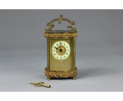 A French Brass Carriage Clock, have bevelled glass panels, ivorine enamel face with numeric dial, brass scrolling fascia, pla