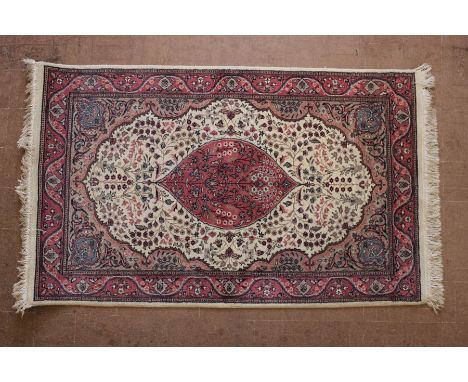 A Pink and Beige Wool Rug; the rug having a central medallion in pink surrounded by beige and light brown with a pink border,