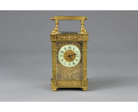 A French Brass Carriage Clock, having filigree panels, ivorine enamel face with numeric dial surrounded by a fretwork of flor