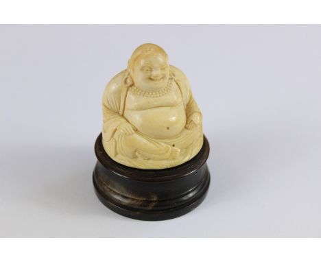 Antique Ivory Carved Netsuke depicting Buddha seated in the Lotus position, approx 6 cms h, supported on a circular horn plin