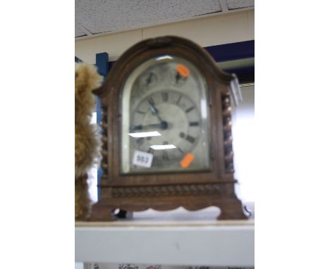 AN OAK CASED BATTERY OPERATED MANTEL CLOCK