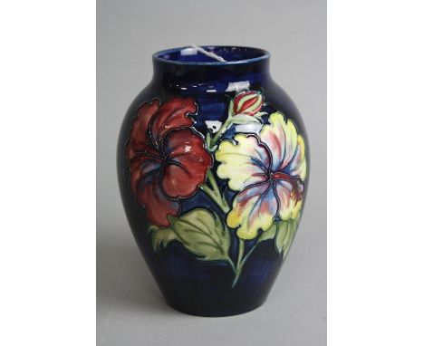 A MOORCROFT POTTERY BALUSTER VASE, 'Hibiscus' pattern on blue ground, impressed marks and paper label to base, height approxi