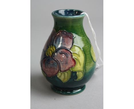 A SMALL MOORCROFT BALUSTER VASE, 'Clematis' pattern on green ground, impressed marks to base, height approximately 10cm