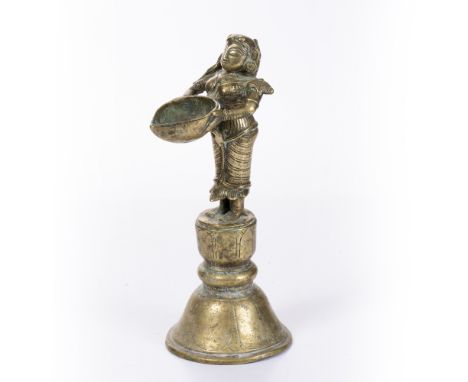 A 19TH CENTURY SOUTH INDIAN BRASS OIL LAMP, figure of lakshmi depicted holding a dish, 24cm high&nbsp;&nbsp;