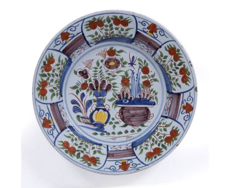 AN 18TH CENTURY ENGLISH DELFTWARE POLYCHROME CHARGER, decorated with two central floral vases, circa 1740, 34.5cm wide 