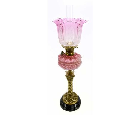 A Victorian oil lamp, cranberry and frosted glass shade with etched floral decoration on a panelled ground, above the cramber