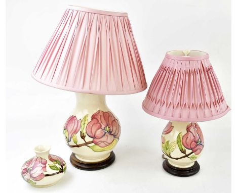 MOORCROFT; a graduated pair of lamps and a squat vase decorated in the 'Pink Hibiscus' pattern, the lamps with pink pleated s