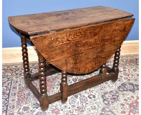 An 18th century oak oval drop-leaf gateleg table on bobbin turned supports, length 110cm.