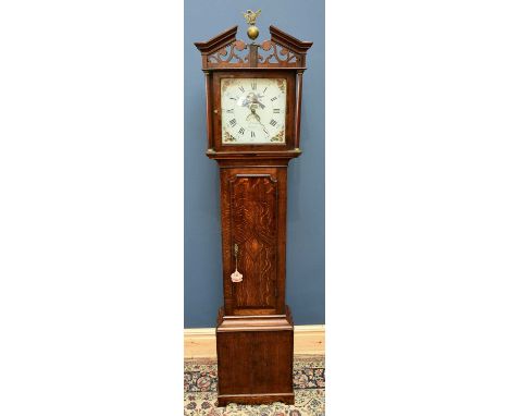 An early 19th century oak and mahogany crossbanded thirty hour longcase clock with arched pediment above painted dial set wit