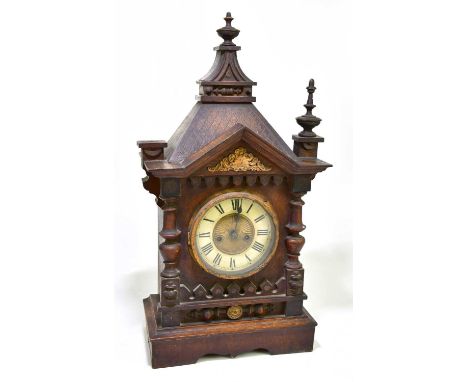 An early 20th century stained pine German mantel clock, the circular dial set with Roman numerals, height 57cm.
