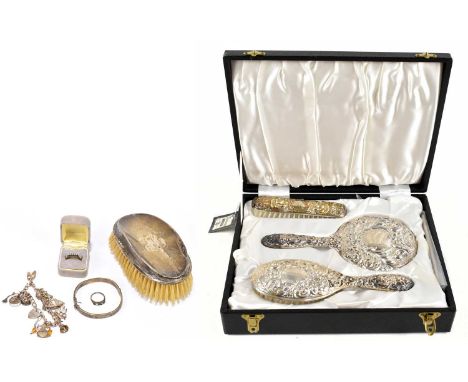 An Elizabeth II cased three piece silver backed dressing table set, Birmingham 1975, with a hallmarked silver backed clothes 