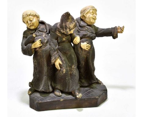 A German ceramic figure group of three drunken monks, height 22cm, length 24cm.