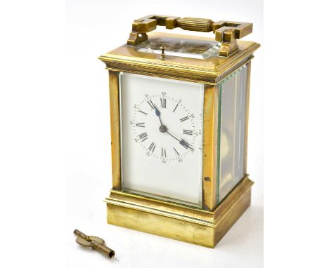 A late 19th century French brass repeating carriage clock with swing loop handle above white enamel dial set with Roman numer