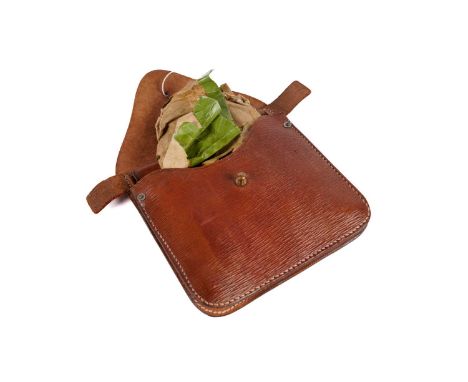 A WWII trench saw in greased proof paper, the leather pouch stamped with broad arrow and 'P.I. 1943'.