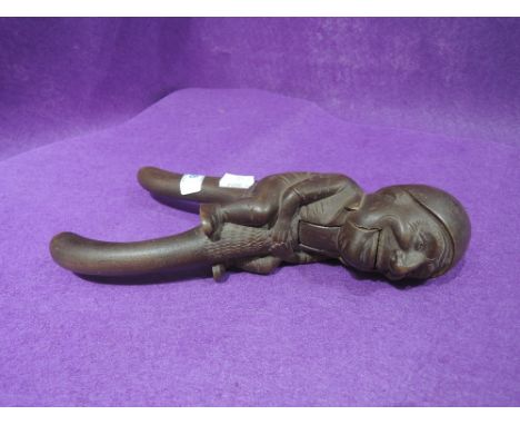 A vintage treen nut cracker in a black forrest style marked chillon