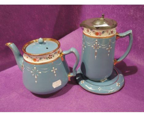 A vintage teapot and water jug set with hand decorated enamel and teal glaze