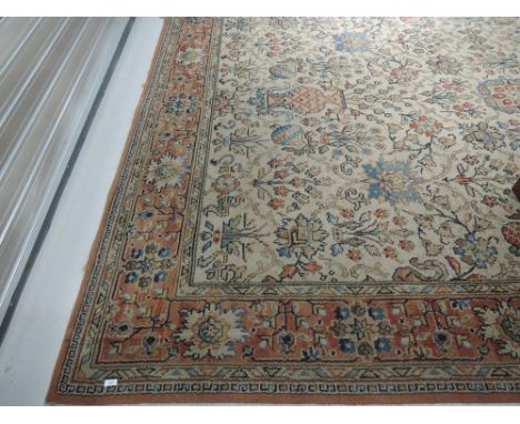 A vintage patterned carpet square having floral vase and fruit design