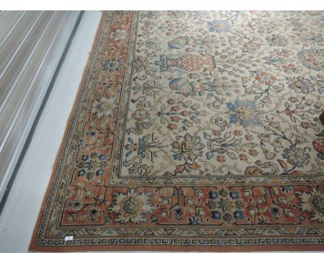 A vintage patterned carpet square having floral vase and fruit design