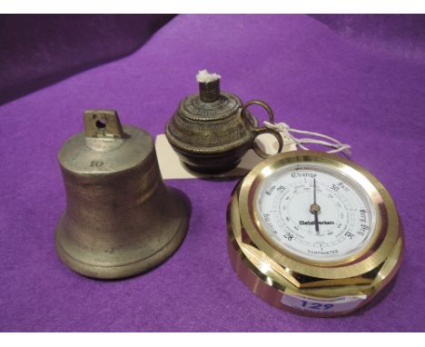 A decorative brass oil lamp of middle eastern style, a brass barometer and a brass bell