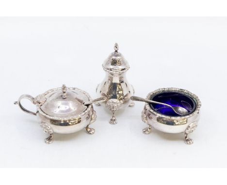 A Georgian style  silver cruet set comprising salt, pepper and mustard pot complete with spoon and blue glass liners, gadroon