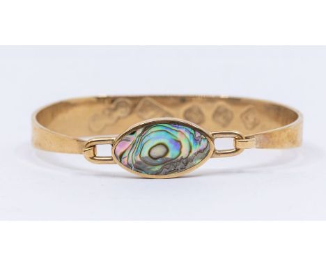 A 9ct gold and abalone set bangle, hinged top set with an oval abalone, width approx 15mm, internal diameter approx 65mm, fea