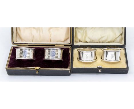 Two pairs of early 20th Century silver napkin rings, engine turned and plain, both hallmarked, cased, approx 2.28 ozt (70.9 g