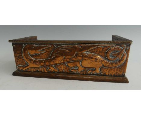In the manner of John Pearson - an Arts &amp; Crafts oak and embossed copper mounted book trough, the copper decorated with s