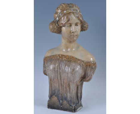 An Austrian Art Nouveau Goldscheider painted pottery female bust, looking to sinister, her hair in netted headrest decorated 