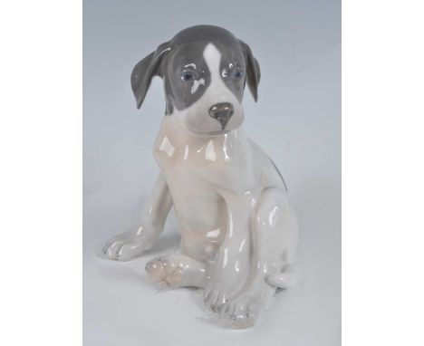 A Royal Copenhagen model of a seated puppy dog, glazed porcelain, printed backstamp and painted number '1452/259' verso, h.20