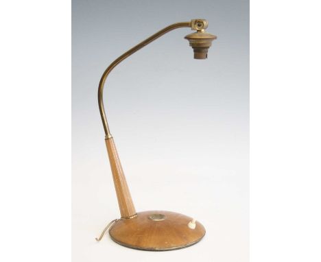 A 1950s walnut and brass desk lamp, the fixed shaped rod arm over tapering support to integral slightly domed base, with on/o