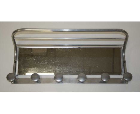 A 1960s aluminium framed and mirror inset wall mounted Pullman luggage rack, the swing mirror over six integral button shaped