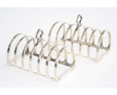 A pair of 1960s silver six-division toast racks, each of domed form with shaped central carry handle, maker Mappin &amp; Webb