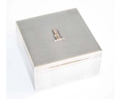 An Art Deco silver square table cigarette box, having a gold cross mount to cover, all-over engine turned exterior and gilt-w