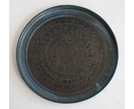 A Troika Pottery circular plate, having a raised edge, with impressed stylised circular banded repeating ground, printed back
