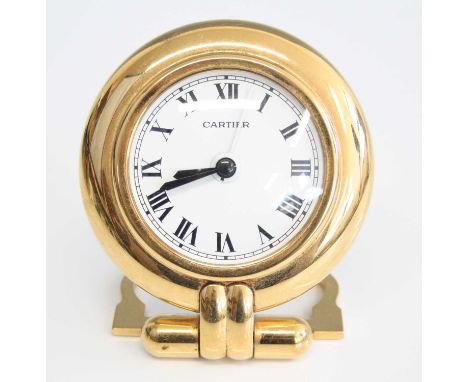 A Cartier 'Colisee' gilt brass travel alarm clock, circa 1990s, having white enamel dial with Roman numerals, hinged rear sup