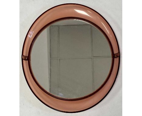 Possibly Harvey Guzzini - a 1970s Italian peach coloured polypropylene framed circular wall mirror, 50 x 43.5cmSome light sur