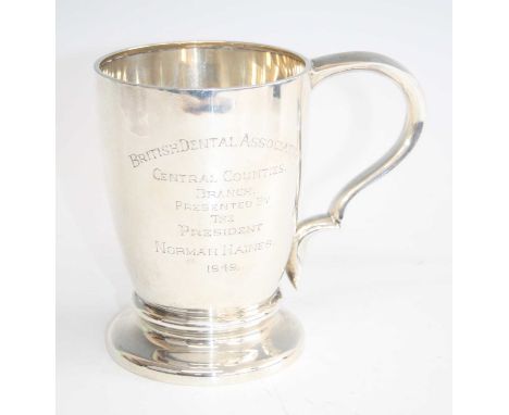 A late Art Deco silver tankard, having a shaped and pinched handle to cylindrical gently bulbous tapering body and squat foot